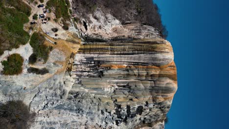 vertical-view-of-hierve-el-agua-waterfall,-close-view-zoom-out-movement-drone-sight-in-oaxaca,-mexico