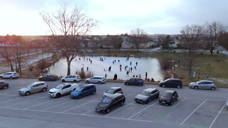 Aerial-View-Of-Frozen-Lake-With-People-Ice-Skating---Drone-Shot