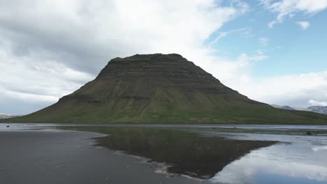 Vuelo-Bajo-Sobre-El-Agua-Que-Refleja-La-Exuberante-Formación-Montañosa-De-Kirkjufell