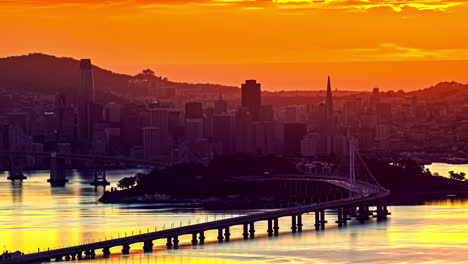 Zeitraffer,-Rote-Und-Gelbe-Farben-über-San-Francisco,-USA,-Abendsonne,-Gebäude-In-Der-Innenstadt-Und-Verkehr-Auf-Der-Oakland-Bridge