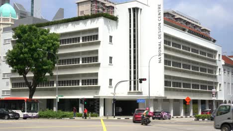Straßenszene-Und-Fahrende-Fahrzeuge,-Und-Vor-Dem-Hintergrund-Fassadenansicht-Des-National-Design-Centre-Singapore