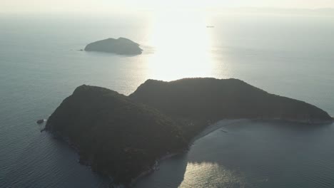 Paisaje-Aéreo-De-Drones-En-El-Islote-Japonés-De-La-Isla-Del-Amanecer-Con-El-Sol-Brillando-Reflejando-Las-Vibraciones-Del-Océano-Pacífico-En-El-Verano-Japonés-En-La-Costa-De-Wakayama