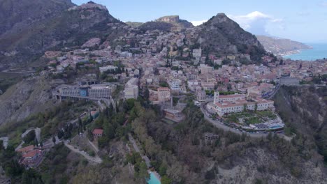 Aerial-wide-orbit-over-Taormina,-Sicily,-Italy-a-south-side-of-the-city-on-the-volcano