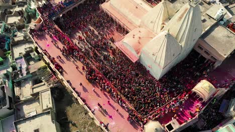 Vista-Aérea-De-Drones,-La-Toma-De-Arriba-Hacia-Abajo-Avanza-Y-Muchas-Personas-Están-Jugando-Dhule-Con-Muchas-Personas-Mirando-Desde-Arriba