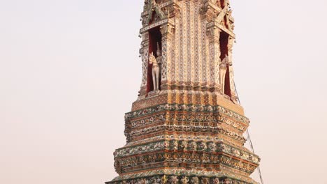 looking-up-at-towering-detailed-pagoda-spire-in-a-buddhist-temple-complex-in-the-Rattanakosin-old-town-of-Bangkok,-Thailand