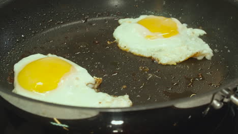 Close-up-view:-Eggs-with-yellow-yolks-fry-crispy-brown-in-hot-skillet