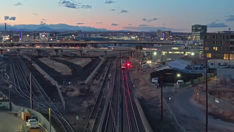 Aerial-dolly-above-public-transit-tram-train-line-railroad-at-dusk-in-Denver-Colorado-suburb