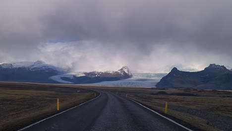 Driving-on-Iceland,-Driver's-POV-of-Wet-Road-and-Glacier,-Icelandic-Landscape-on-Spring-Season