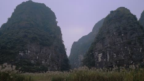 -Ninh-Binh-Wetland-Reserve-With-Flock-Of-Birds-Flying-In-Background-Against-Towering-Limestone-Karsts-In-Vietnam