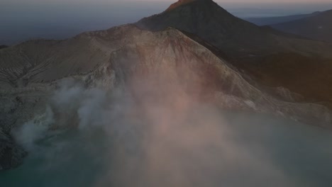 Morgendliche-Drohnenaufnahmen-Fangen-Vulkanische-Aktivität-Und-Rauch-Mit-Einem-Wunderschönen-Sonnenaufgangslicht-Ein