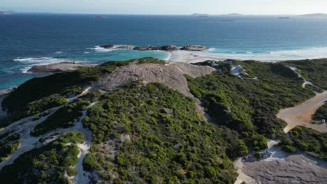 Aerial-approaching-shot-of-green-coastline-with-rocky-beach-at-Wylie-Bay,-Australia