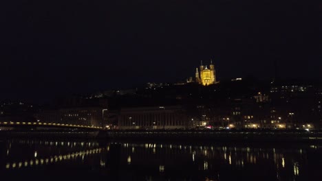 Fourvière-basilica-in-Lyon,-France-view-from-the-quays-at-night