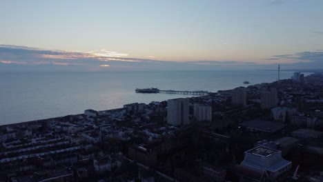 Ciudad-Costera-De-Playa-Panorámica-Aérea,-Paisaje-De-Horizonte-De-Puesta-De-Sol-De-Drones-Frente-Al-Mar-En-Brighton-East-Sussex,-Toma-De-Establecimiento