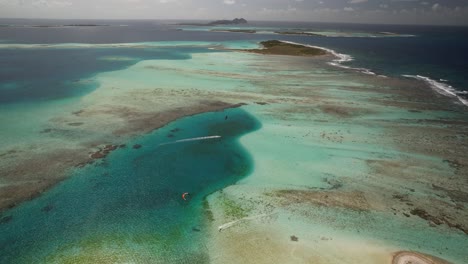 Eine-Ruhige-Tropische-Insel-Mit-Leuchtend-Türkisfarbenem-Wasser-Und-Korallenriffen,-Unter-Einem-Klaren-Himmel,-Luftaufnahme