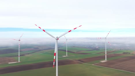 Rotating-Wind-Turbines-Over-Misty-Rural-Farmlands