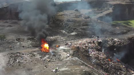 Establishing-Shots-showing-people-burning-plastic-waste-and-large-dumping-yard-drone-camera