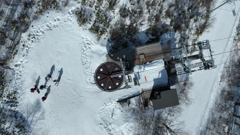 Top-down-shot-of-chair-lift-at-summit-of-mountain