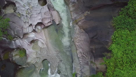 A-leisurely-aerial-perspective-captures-the-Babinda-Boulders-in-Cairns,-Australia,-showcasing-the-rapid-currents-coursing-through-its-granite-formations,-enveloped-by-lush-green-foliage