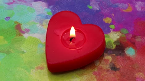 Red-heart-shaped-candlelight-on-a-painter's-color-palette