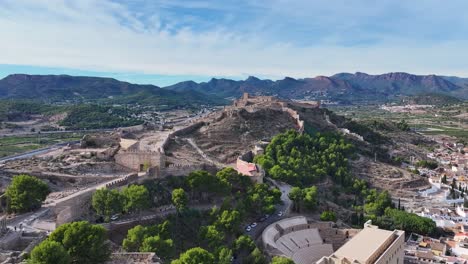 Rodaje-De-Alta-Calidad-Con-Un-Dron-Orbitando-El-Castillo-De-Sagunto-Y-Sus-Murallas-Ubicadas-En-Una-Colina-Vemos-El-Anfiteatro-Romano-Con-Un-Fondo-De-Montañas-Y-Un-Cielo-Con-Nubes-Valencia-España