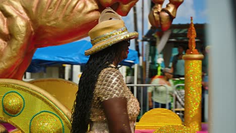 Golden-horse-float-and-women-in-gold-fishnet-costume-walks-by-blowing-kiss-and-smiling
