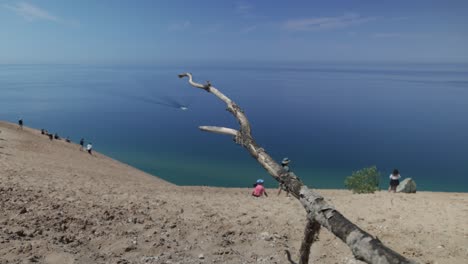 Sleeping-Bear-Sand-Dunes-National-Lakeshore-overlook-of-Lake-Michigan-in-Michigan-with-people-and-deadwood-with-gimbal-video-walking-forward
