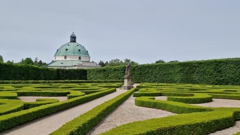 Landscape-of-Kvetna-zahrada-garden-in-Kromeriz,-Czech-Republic-with-pavillion-in-the-background,-wide-angle-panning-shot