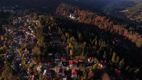 Sinaia-with-peles-castle-and-bucegi-mountains-during-autumn,-aerial-view