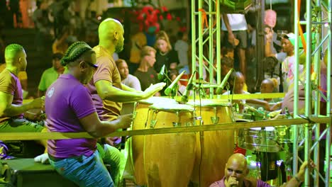 Telephoto-closeup-of-performers-drumming-on-bongo-drums-during-Carnival-float-performance-at-night