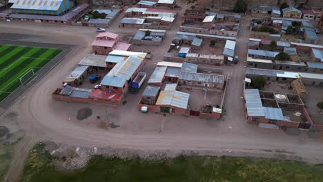 A-colorful-small-town-in-chile-with-surrounding-desert-landscape,-at-dusk,-aerial-view