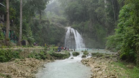 Rainy-rainforest-with-tourists-visiting-the-Kawasan-falls-in-Cebu,-Philippines