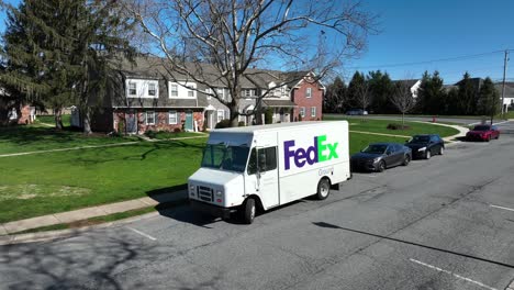 Swarthy-male-Fedex-delivery-driver-coming-back-to-truck-and-leaving-neighborhood