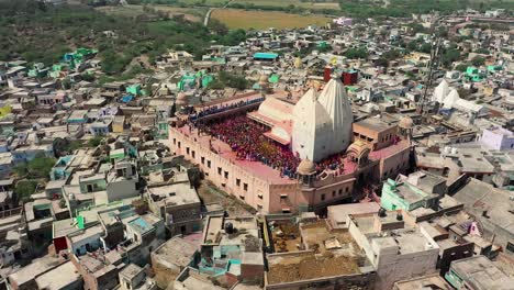 aerial-drone-view-don-camera-is-going-backwards-where-many-people-are-playing-dhulete-dance-and-many-flying-colors