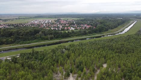Kleines-Dorf-Neben-Einem-Kontrollierten-Flusskanal-Und-Seewald