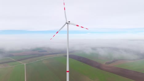 Windturbine-Mit-Roten-Streifen-Auf-Den-Rotorblättern-An-Einem-Nebligen-Morgen-Im-Windpark