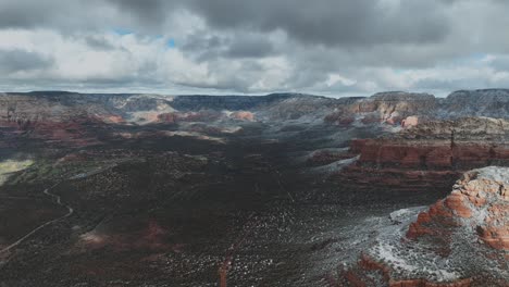 Schneebedeckte-Rote-Felsenberge-Vor-Bewölktem-Himmel-In-Sedona,-Arizona---Luftaufnahme-Per-Drohne