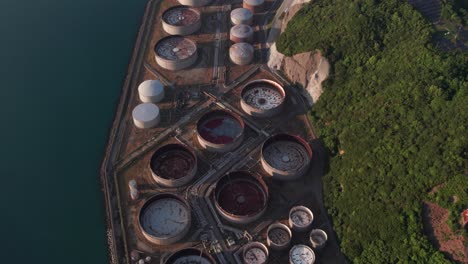Luftaufnahme-Einer-Drohne-Aus-Der-Vogelperspektive:-Ölraffinerielandschaft-Im-Japanischen-Ozean,-Küstenwald-In-Hügeln,-Benzintanks,-Zeitlupen-Einspielung-In-Wakayama,-Japan