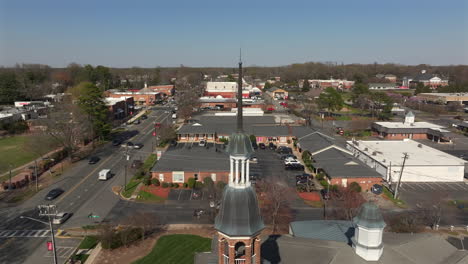 Orbit-of-First-Baptist-Church-Matthews-NC-steeple-during-afternoon-rush-hour-in-early-spring-showing-downtown-Matthews-NC