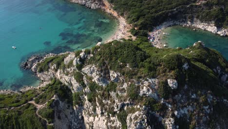 Revealing-Aerial-over-the-Rocks-of-Porto-Timone-Beach,-Corfu,-Greece