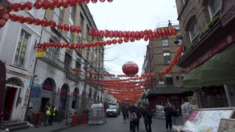 POV-Walking-Along-Chinatown-Gerrard-Street-In-London-With-Red-Hanging-Lanterns-Swaying-Overhead-As-White-Vans-Unload-Morning-Deliveries