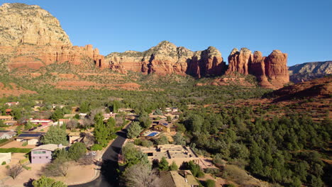Sedona-AZ-USA,-Aerial-View-of-Residential-Community,-Homes-Under-Red-Rock-Sandstone-Cliffs