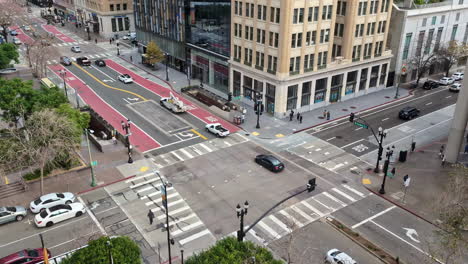 Vista-Aérea-De-Una-Concurrida-Intersección-De-Oakland-Con-Tráfico-Esperando-Una-Señal-Y-Cruzando