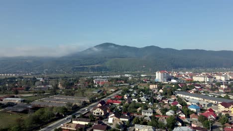 Piatra-Neamț,-Moldavia-Occidental,-Rumania---Un-Encantador-Paisaje-Urbano-Con-El-Telón-De-Fondo-De-Las-Montañas-De-Los-Cárpatos-Durante-La-Temporada-De-Verano---Drones-Volando-Hacia-Adelante