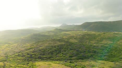 Golden-soft-sunrise-hour-glow-of-light-spreads-across-rolling-hills-of-Westpunt-Curacao