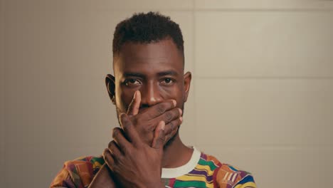 Portrait-Of-African-American-Man-Hiding-Mouth-With-Hands