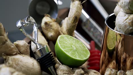 Close-up-zoom-in-of-slice-of-lime-and-cluster-of-ginger-root-surrounded-medicinal-spice-raw