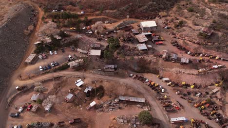 Drone-Shot-of-Jerome-Ghost-Town,-Rustic-Buildings-and-Vehicles-on-Abandoned-Mine