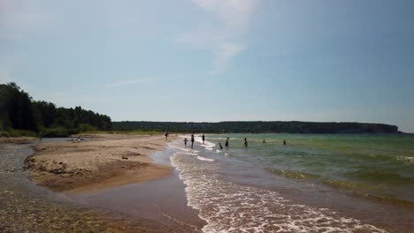 Familien-Schwimmen-Und-Spielen-Am-Sonnigen-Sandstrand-Auf-Gotland-In-Schweden,-Zeitlupe
