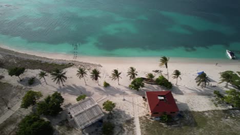 Atemberaubende-Luftaufnahme-Einer-Idyllischen-Tropischen-Insel-Mit-Palmen,-Türkisfarbenem-Meerwasser,-Los-Roques,-Venezuela