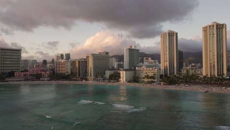 Waikiki-Tropical,-Hoteles-En-La-Costa-De-Hawaii-Al-Atardecer,-Panorama-Aéreo